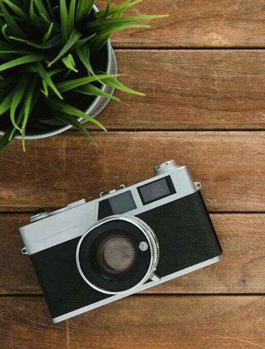 Black and Silver Film Camera on Brown Wooden Surface